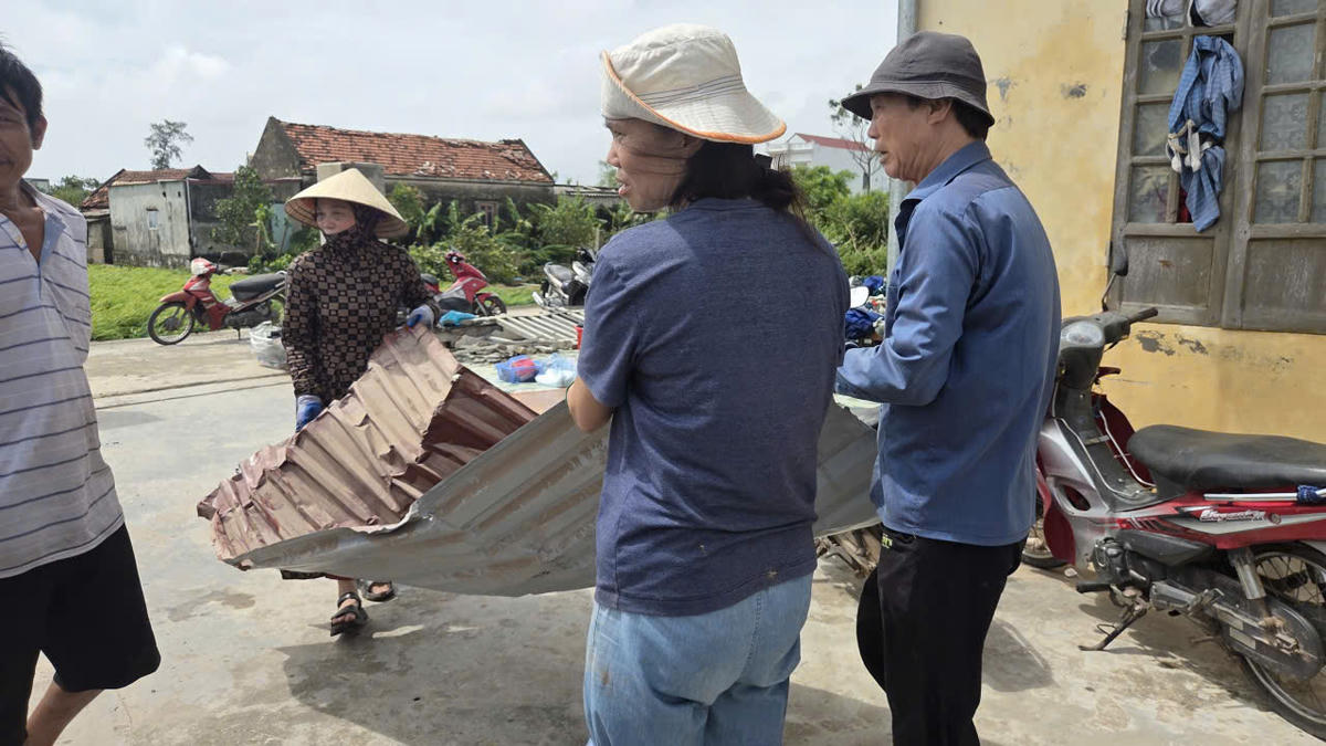 Người dân xã Quỹ Nhất dọn dẹp lại nhà cửa sau khi bị lốc xoáy tàn phá. 	Ảnh: Duy Hưng.