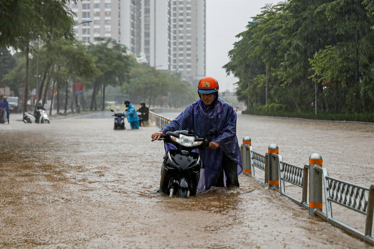 Nước ngập sâu, người dân vất vả di chuyển. .