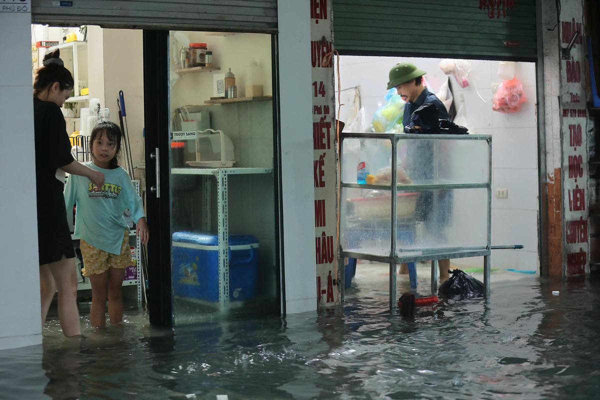Đường ngập úng không thể đi xe: Người Hà Nội 'cõng con' về nhà