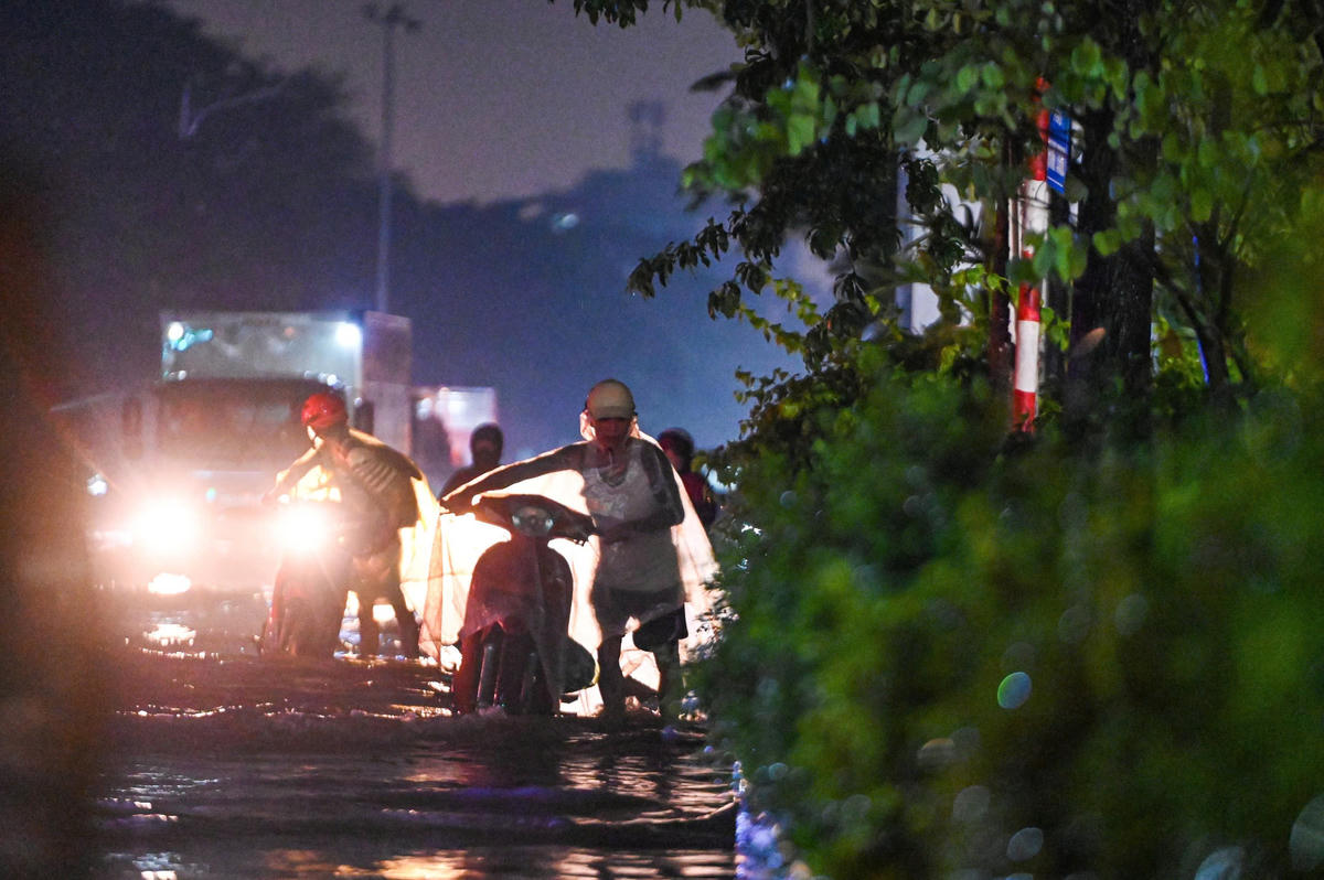 Nước ngập sâu, người dân bì bõm lội nước tại Long Biên.