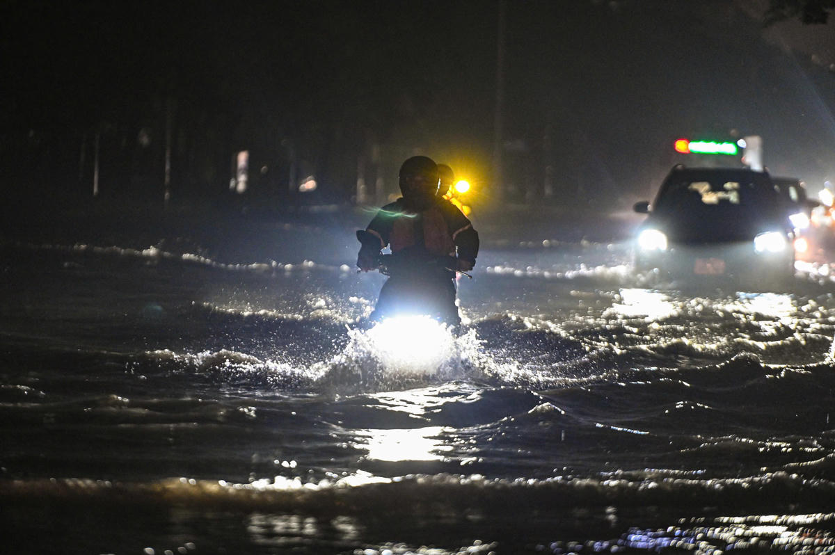 Mỗi khi ô tô di chuyển qua, từng con sóng táp vào khiến các phương tiện đi xe máy mất cân bằng.
