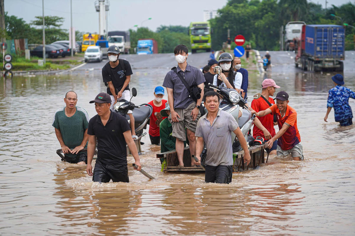 Các phương tiện được để trên xe bò rồi kéo qua vùng nước ngập.