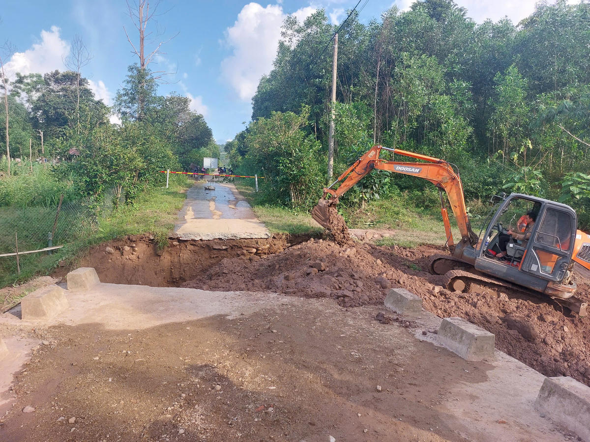 Người và phương tiện được huy động đến khắc phục hiện trường
sập cống thoát nước trên đường liên thôn A Ngo - A Đeng. Ảnh: BPCC.