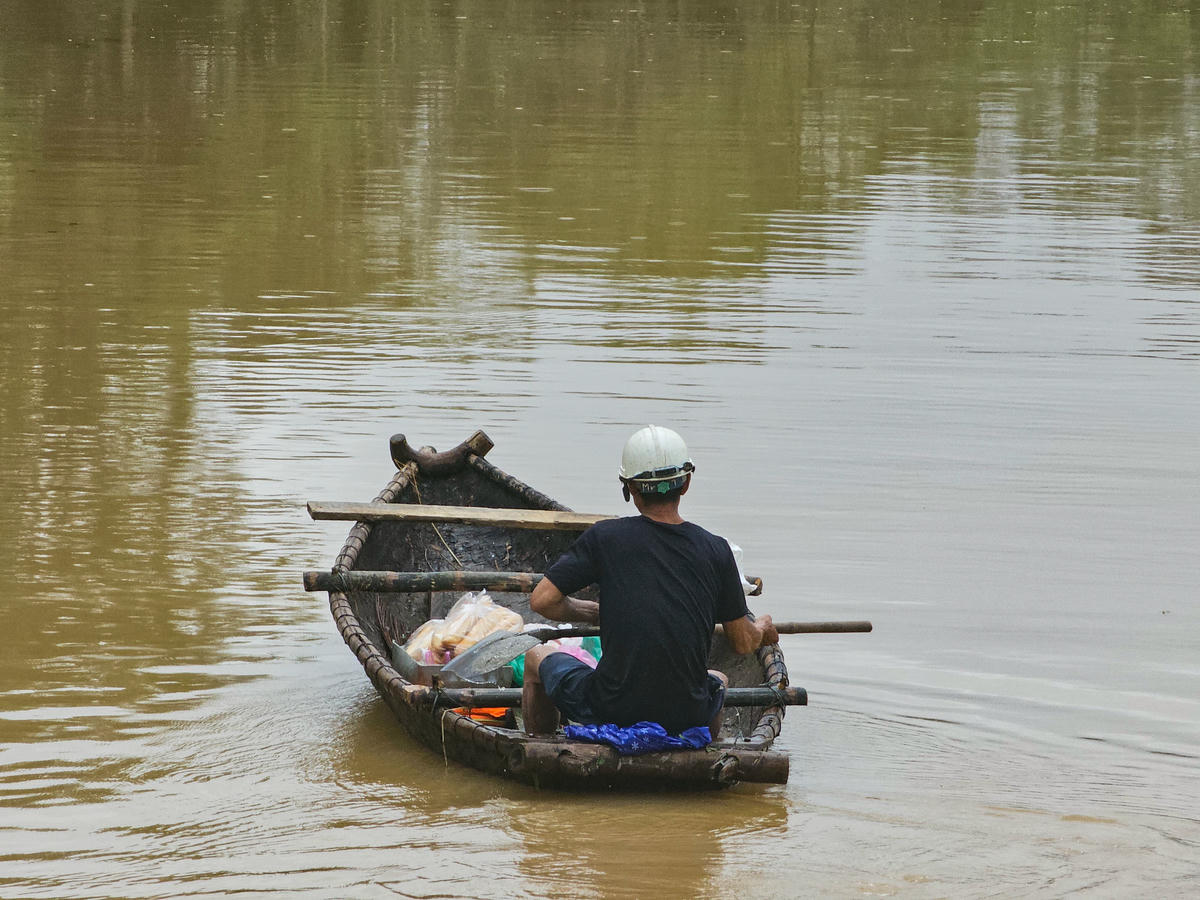 Nhiều hộ dân có thuyền nan tranh thủ tiếp cận khu vực ven đê để nhận nhu yếu phẩm do lực lượng chức năng cung cấp. Ảnh: Đình Minh