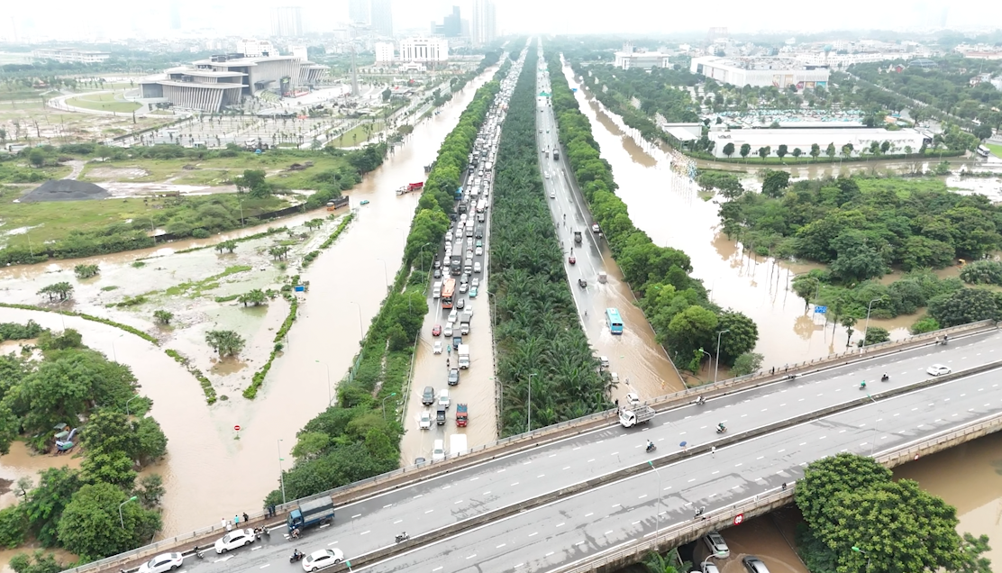 Các phương tiện di chuyển khó khăn, nhích từng chút vượt qua dòng nước sâu.