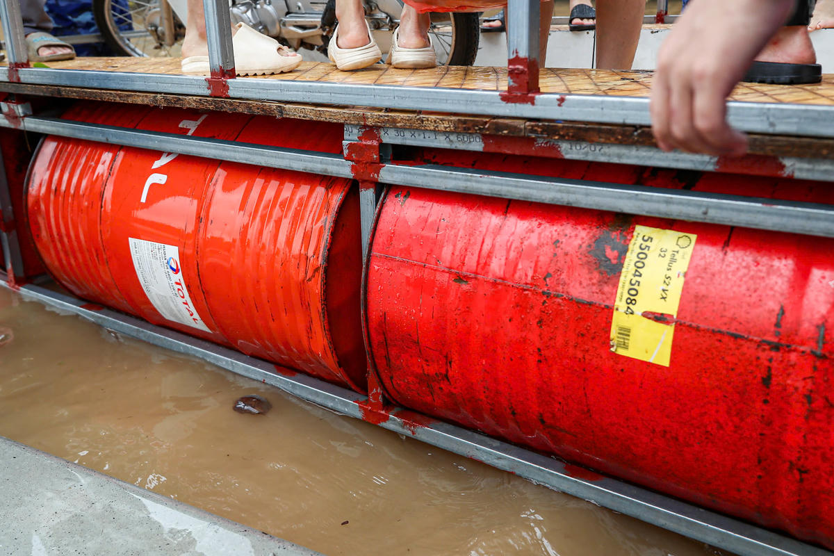 Chiếc phà tự chế được làm bằng các ống kẽm và những chiếc thùng phi.