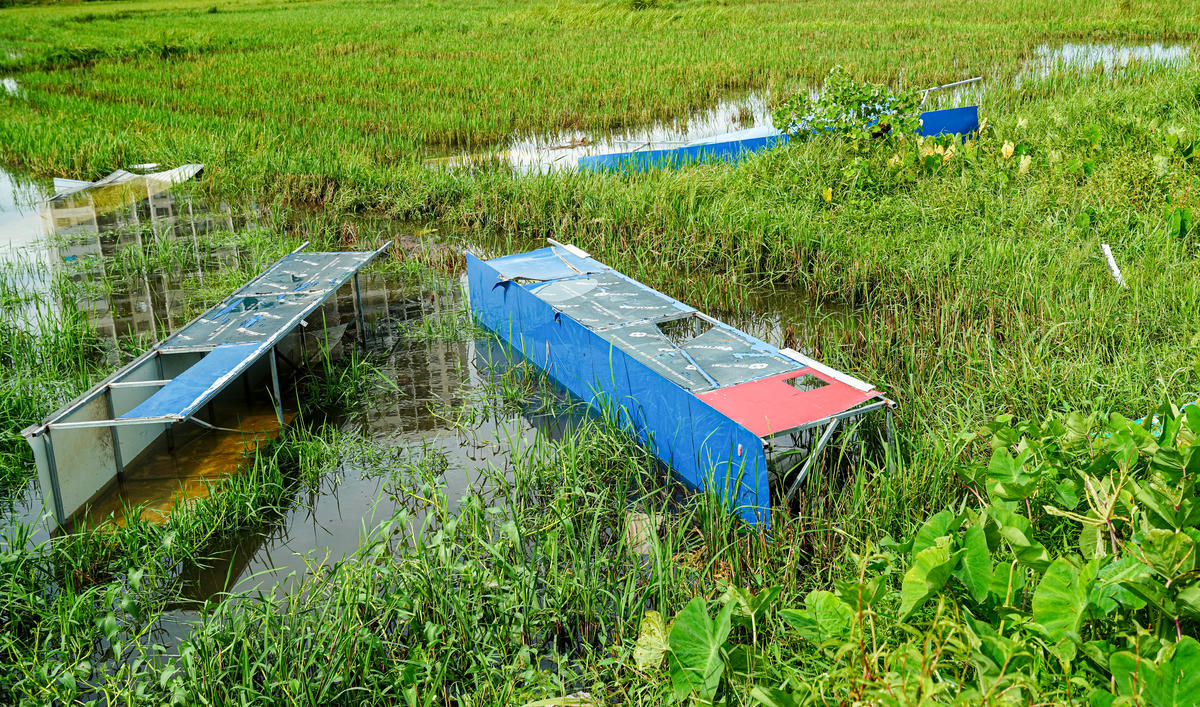 Nhiều bảng hiệu của sân cũng bị gió cuốn ra cánh đồng cách xa chục mét. Ảnh: Cẩm Kỳ