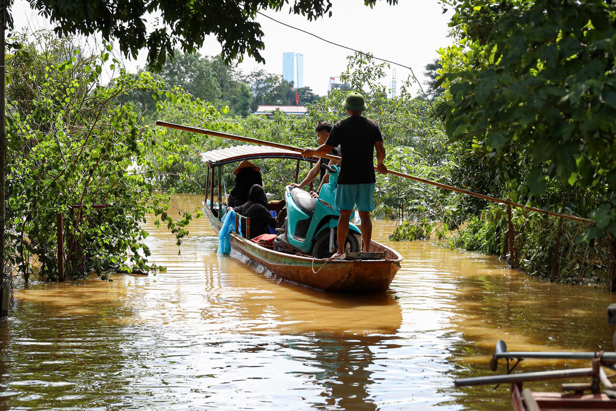 Từng con thuyền liên tục đưa người dân ra khỏi vùng ngập.