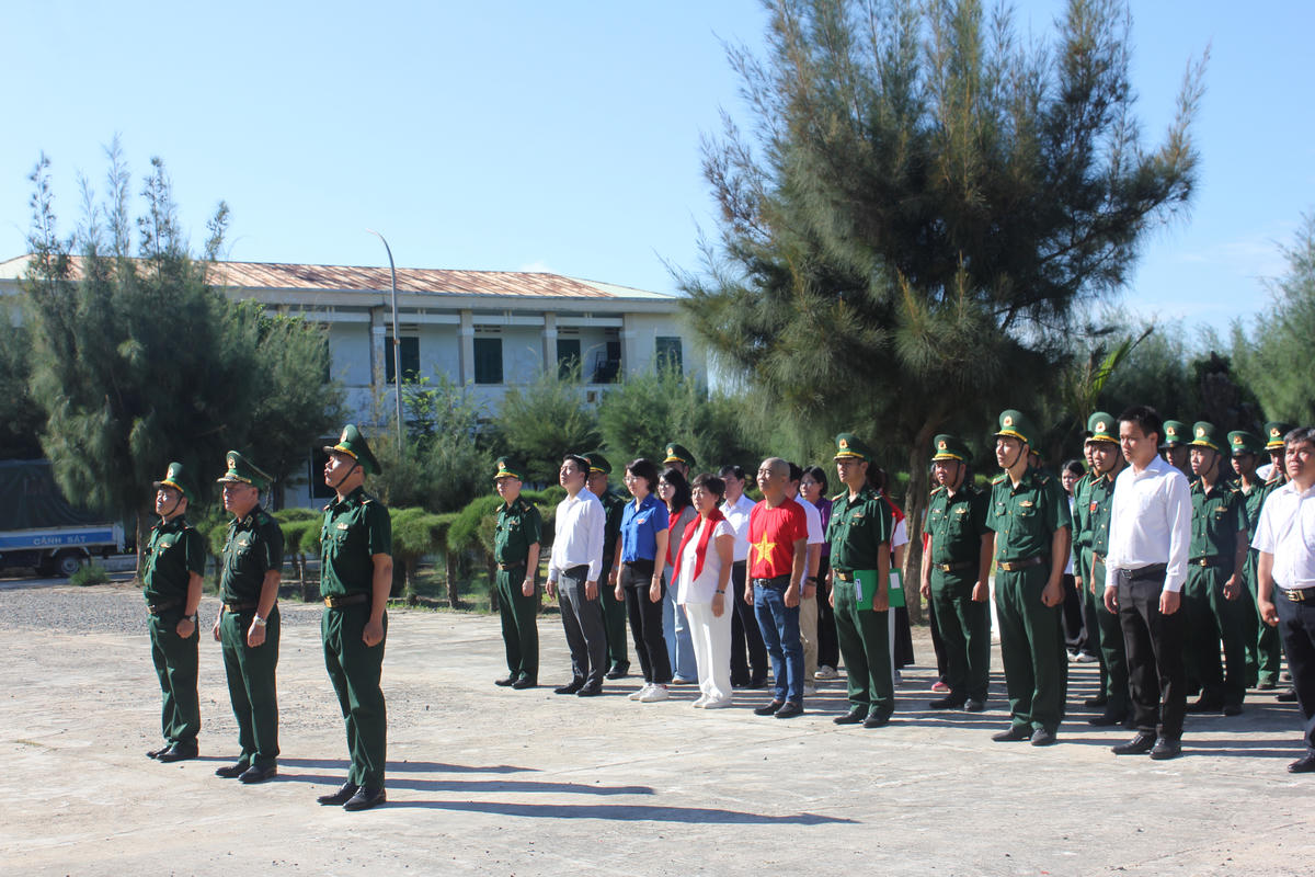 Đoàn công tác cùng các đại biểu làm lễ chào cờ tại Đồn biên phòng Đầm Môn, tỉnh Khánh Hòa. Ảnh: X.H.