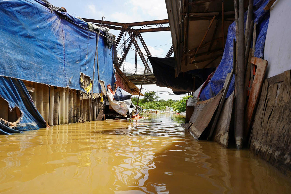 Theo ghi nhận của PV Báo Đại đoàn kết, chiều 2/9 nước sông Hồng dâng cao, người dân xóm ngụ cư dưới chân cầu Long Biên bị ngập úng lao đao, khốn khổ.