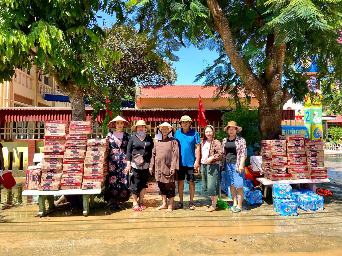 Bà Quách Thị Tươi - Chủ tịch Ủy ban MTTQ Việt Nam xã Kim Tân, tỉnh Thanh Hóa (thứ 2, từ trái qua) đưa hàng cứu trợ tới vùng ngập lụt sáng 2/10.