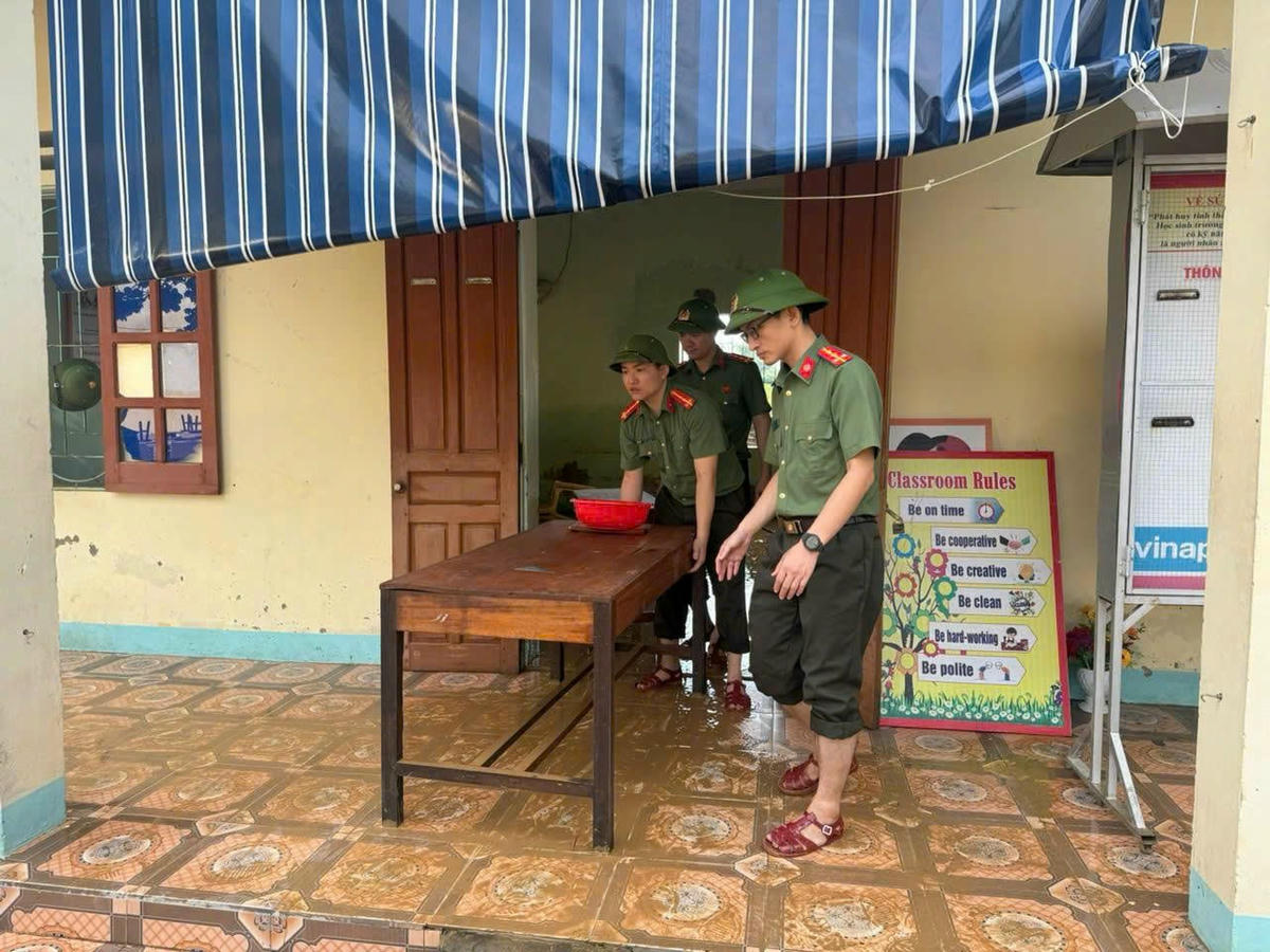 Các chiến sĩ Công an hỗ trợ nhà trường vệ sinh lớp học. Ảnh: CACC