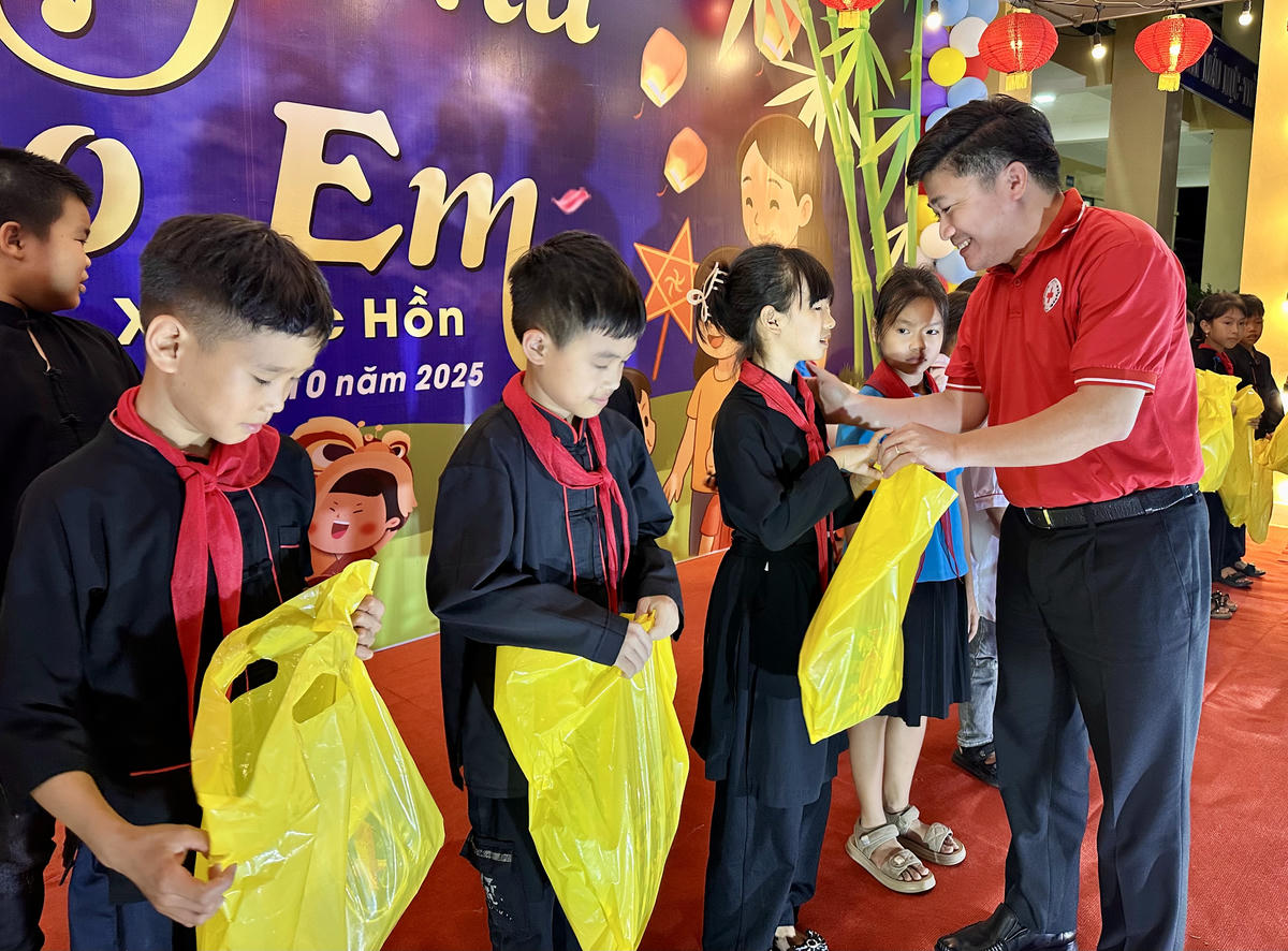 Ông Lý Văn Thành, Chủ tịch Hội Chữ thập đỏ tỉnh Quảng Ninh trao quà cho các em học sinh Trường tiểu học Lục Hồn. Ảnh: Ngọc Anh