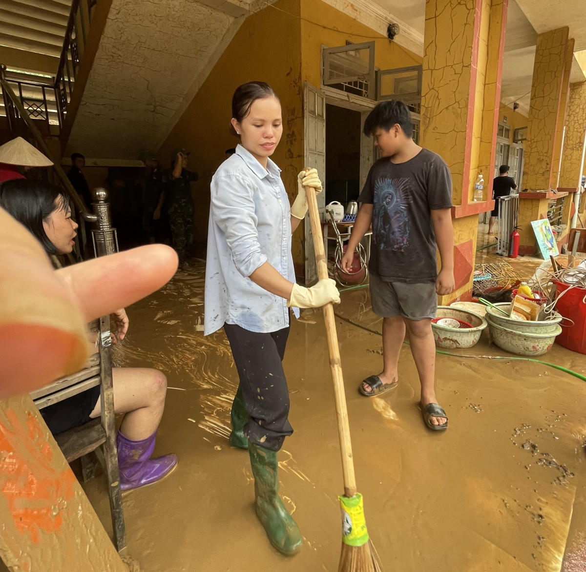 "Các em tham gia vào lau chùi, rửa lại các trang thiết bị, đồ dùng học tập. Còn lại, hơn chục em học sinh cấp 2, có sức khỏe tốt cùng tham gia dọn rác, đẩy bùn đất...", ông Lượng nói với phóng viên Báo Đại đoàn kết. Ảnh: Ngô Hùng.