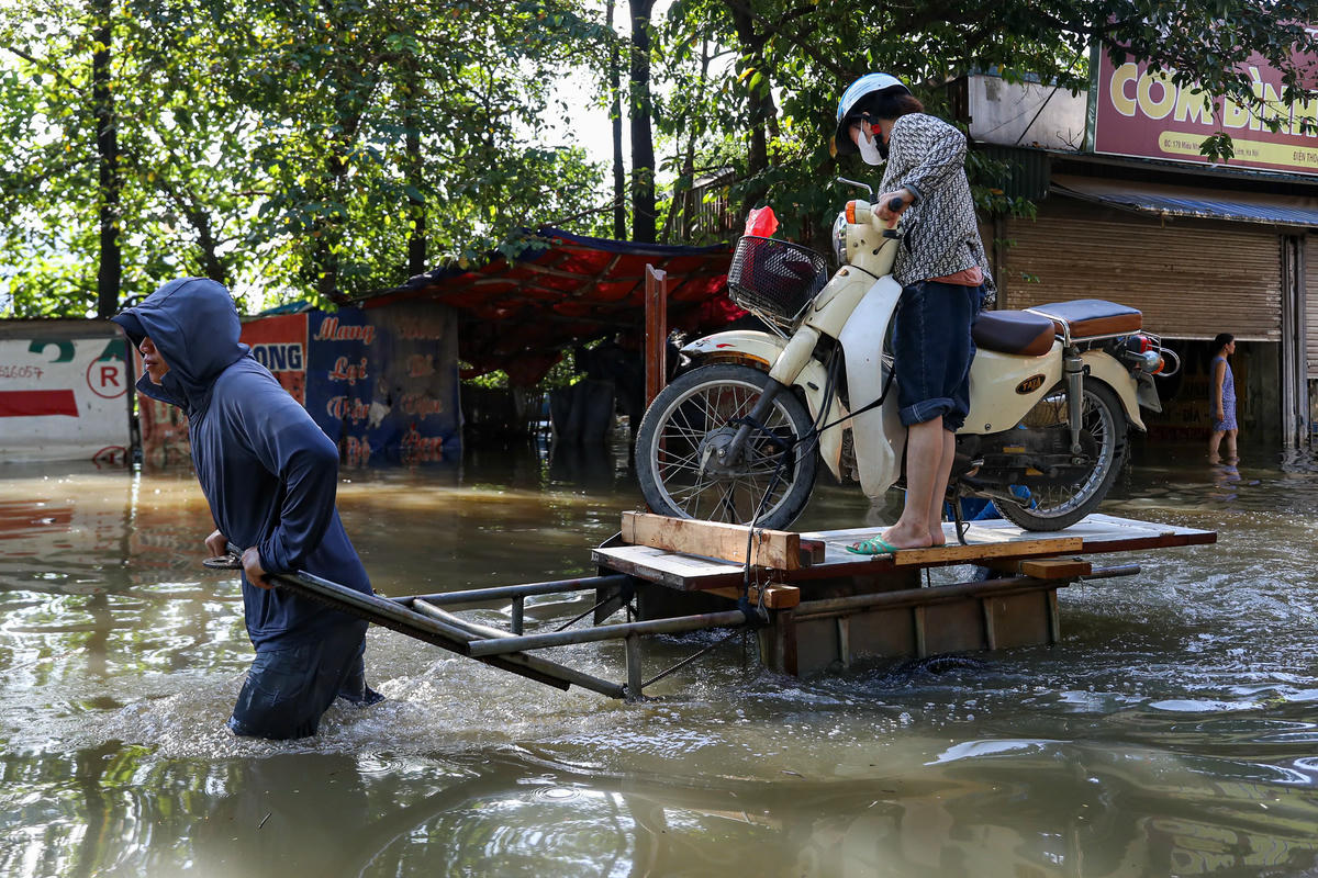 Xe máy cũng được người dân vận chuyển lên điểm cao hơn, bằng những chiếc thuyền tự chế.
