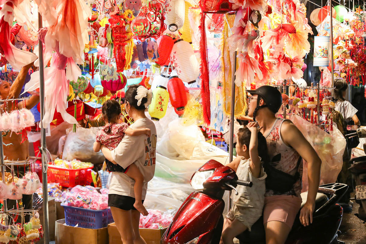 Các em nhỏ được bố mẹ đưa đi mua đồ chơi.