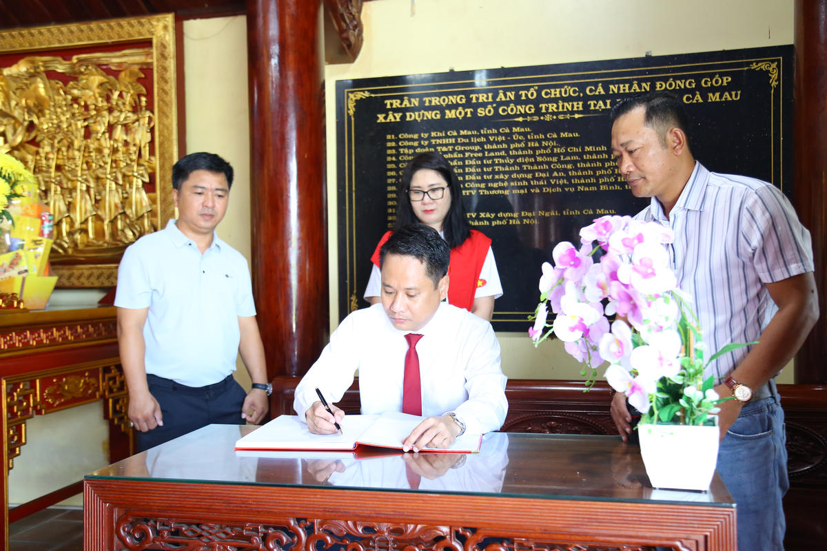 Tổng biên tập Trương Thành Trung viết vào sổ lưu niệm, bày tỏ niềm xúc động và tự hào khi đặt chân tới cực Nam Tổ quốc. 