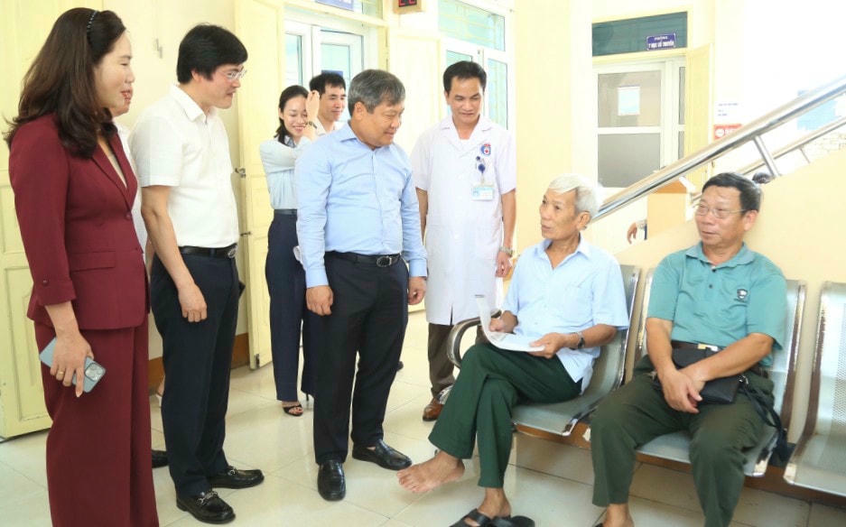 Bí thư Tỉnh ủy Quảng Ninh Vũ Đại Thắng trò chuyện với người dân đến khám bệnh tại Phòng khám đa khoa khu vực Nam Khê khi đi kiểm tra thực tế tình hình hoạt động của các đơn vị y tế tuyến cơ sở sau khi thực hiện mô hình chính quyền địa phương 2 cấp. Ảnh: QMG.