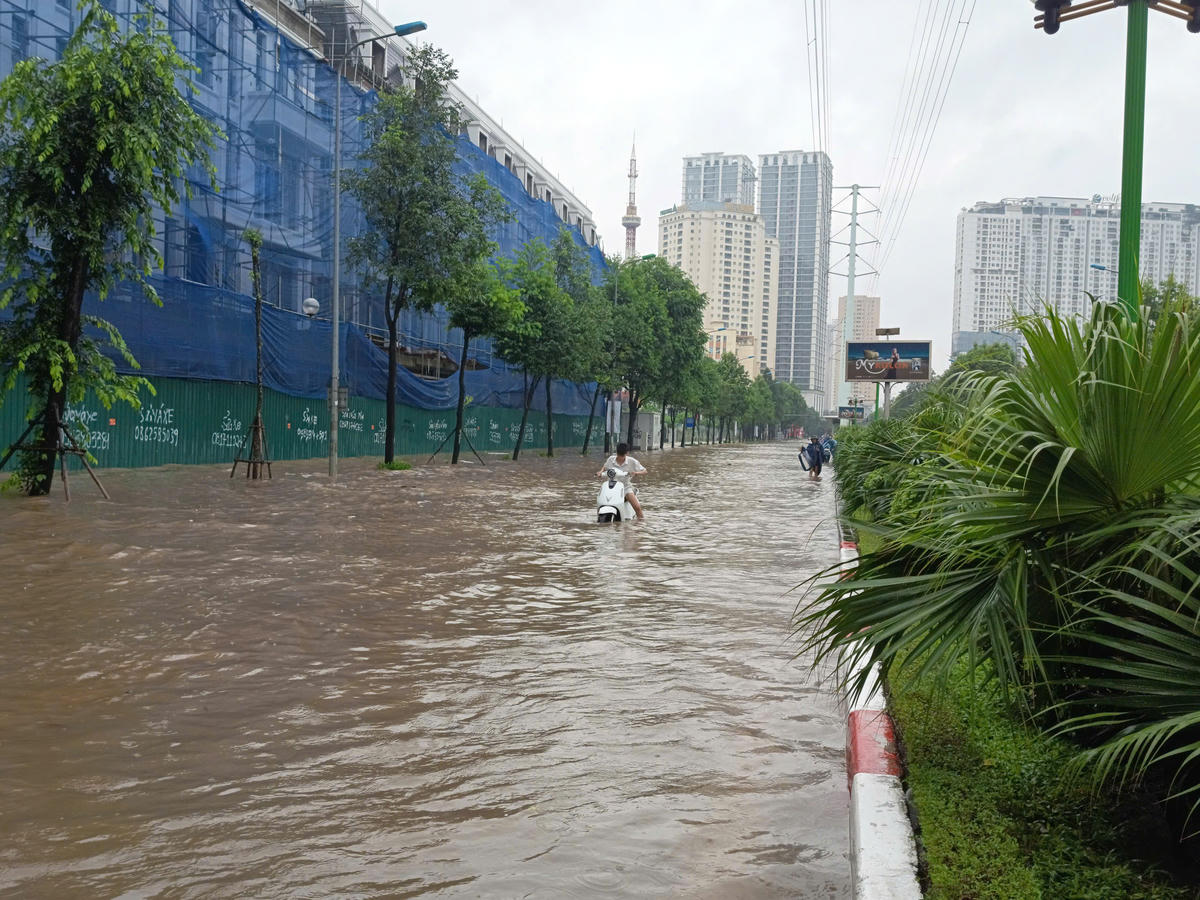 Người đi xe máy vật lộn giữa mênh mông nước.