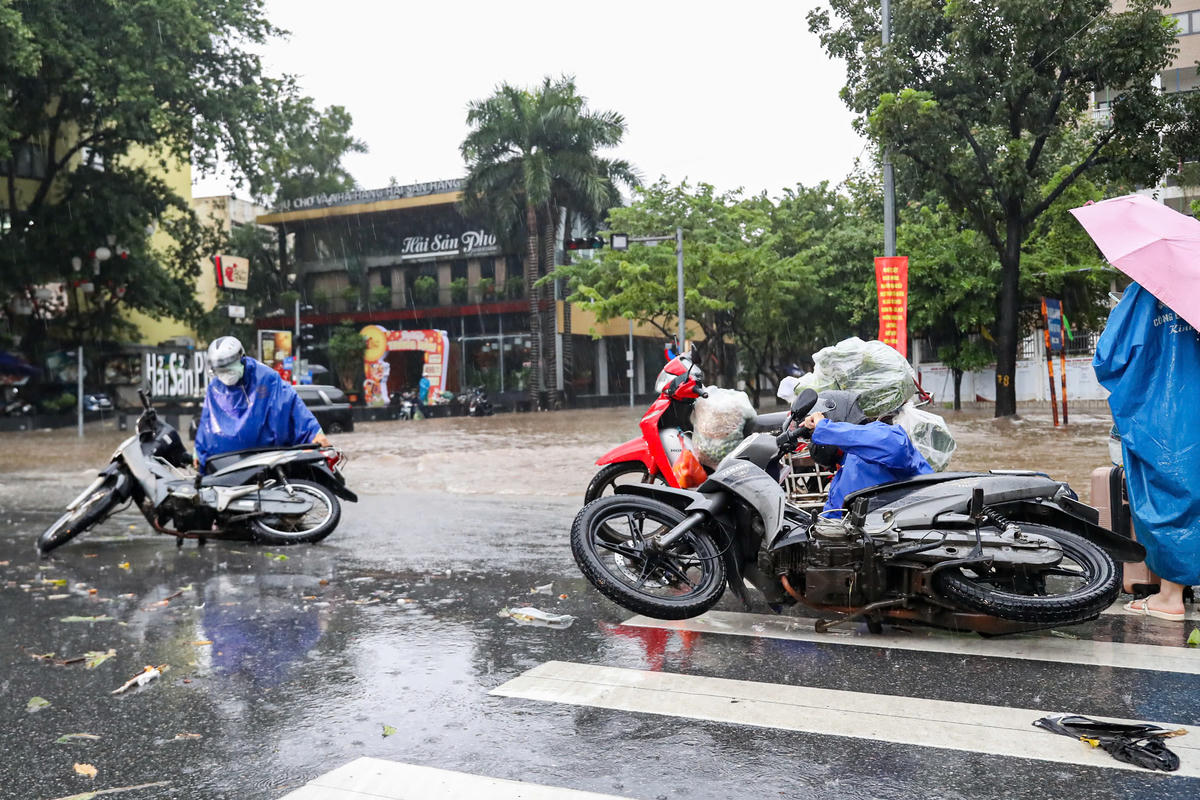 Người dân nghiêng xe để cho nước chảy ra ngoài.