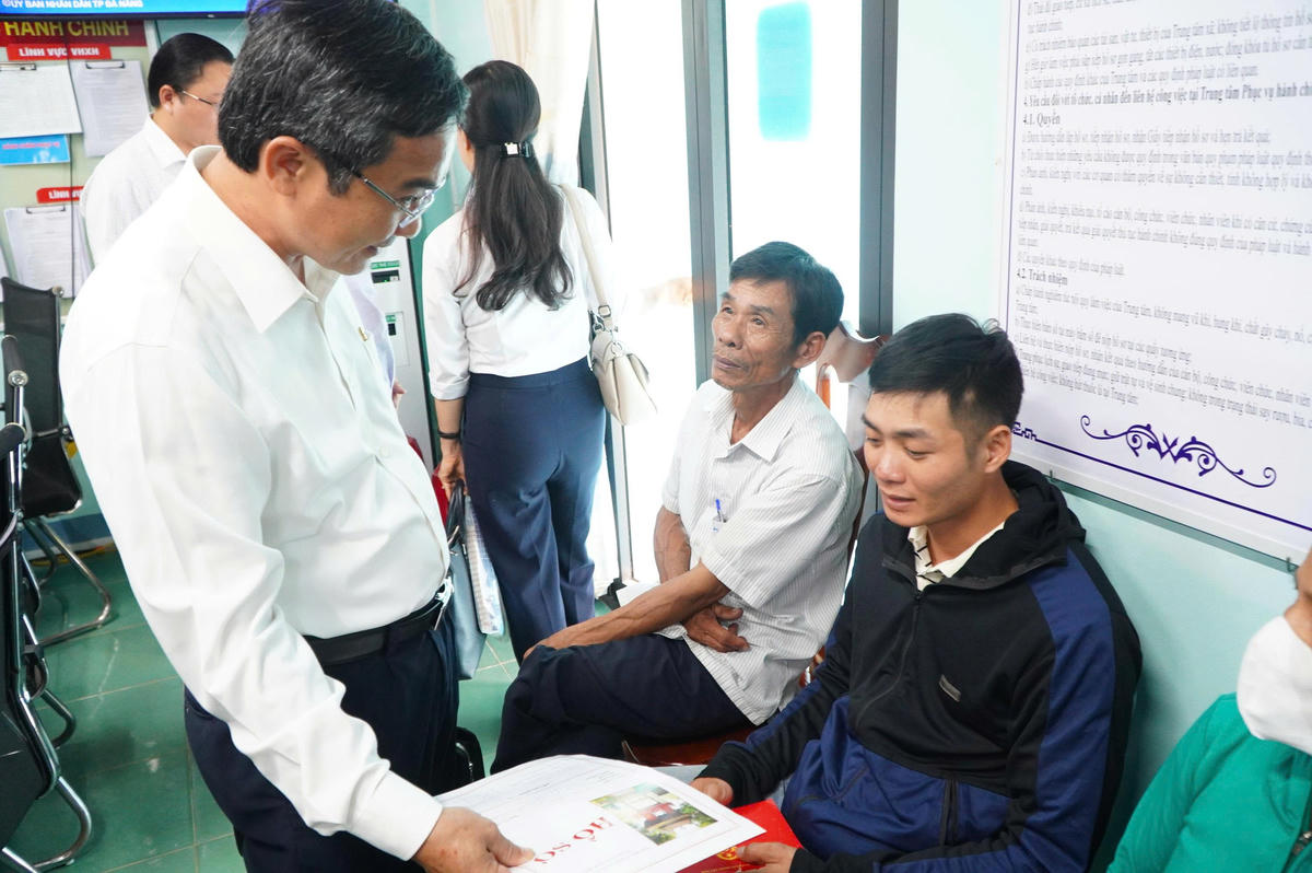 Ông Nguyễn Phi Hùng, Phó Chủ tịch Ủy ban Mặt trận Tổ quốc Việt Nam TP Đà Nẵng thăm hỏi người dân về làm thủ tục giấy tờ. Ảnh: CV.