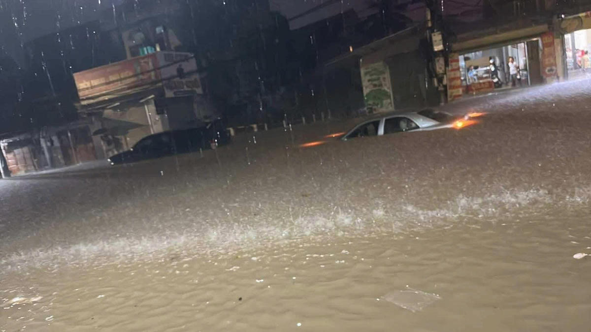 Mưa lớn từ tối 6/10 đến sáng 7/10 khiến nhiều tuyến phố bị ngập, ô tô chìm nghỉm trong nước. Ảnh: Bạn đọc cung cấp. 