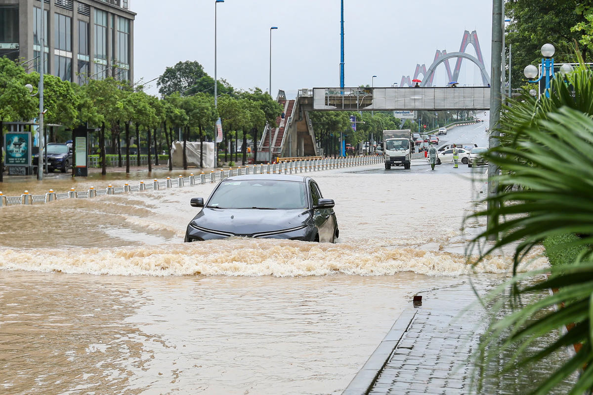 Xe ô tô vất vả vượt qua đoạn đường ngập úng dài hàng trăm mét.