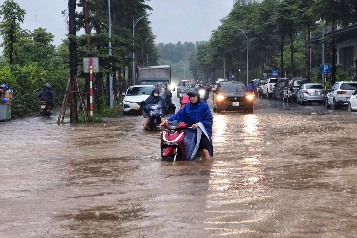 Nước ngập gần hết bánh xe, khiến việc di chuyển của người dân gặp nhiều khó khăn.