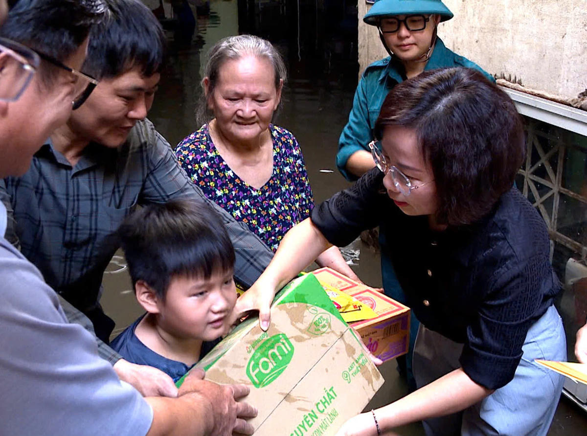 Bà Bùi Huyền Mai trao quà cho người dân bị ảnh hưởng do mưa bão tại phường Từ Liêm. 