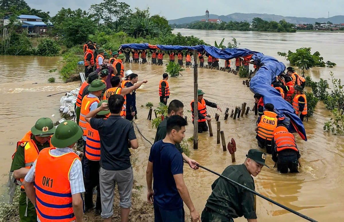 Lực lượng chức năng tỉnh Thái Nguyên gia cố hàng trăm mét đê sông Cầu ở những vị trí xung yếu (Ảnh: Công an tỉnh Thái Nguyên).