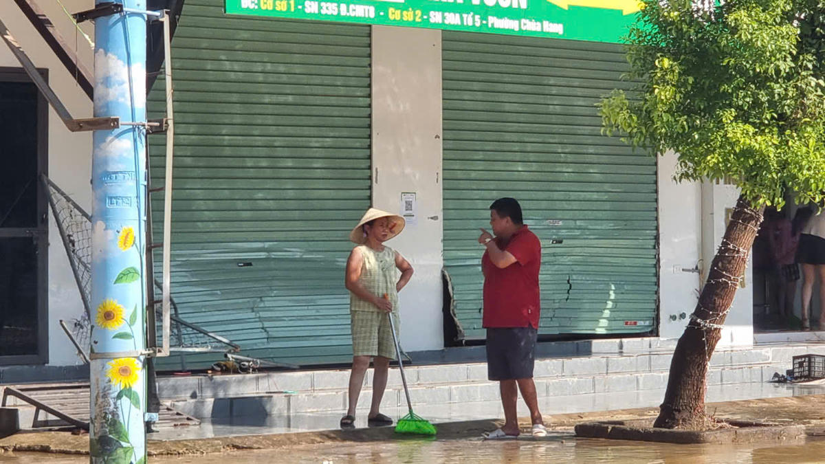 Những cửa cửa cuốn bị nước lũ đánh hỏng trên phố Chùa Hang. Ảnh: TN.