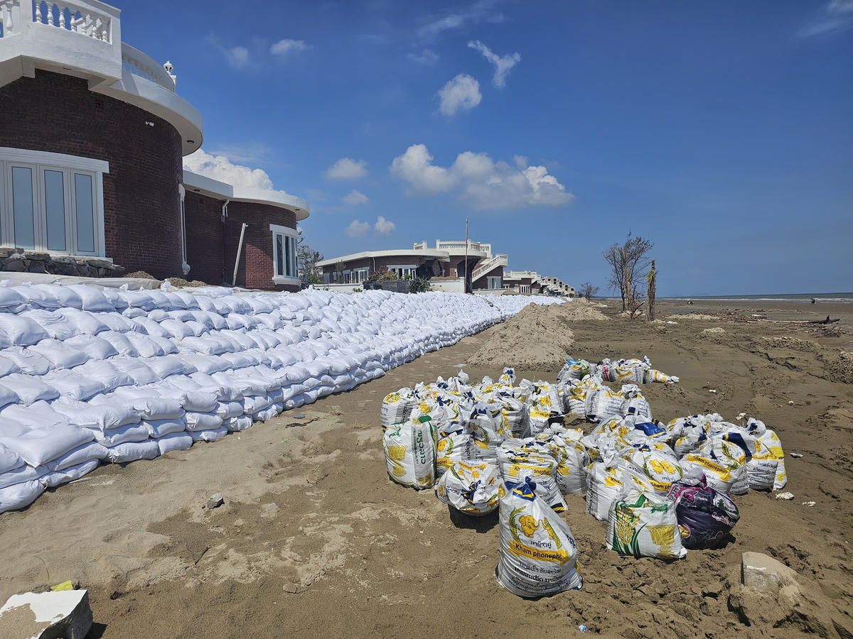 Sau bão, chủ đầu tư đã thuê nhân công, máy móc xúc cát biển cho vào bao tải để đắp tuyến kè tạm che chắn sóng trước dãy villa hướng biển. Ảnh: Quốc Thanh