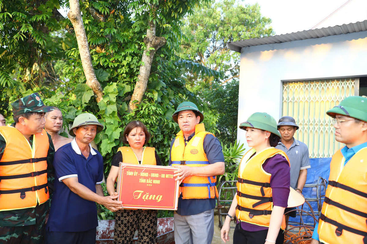 Bí thư tỉnh ủy Bắc Ninh Nguyễn Hồng Thái (thứ ba từ phải sang) trao quà cho hộ dân ở xã Kép