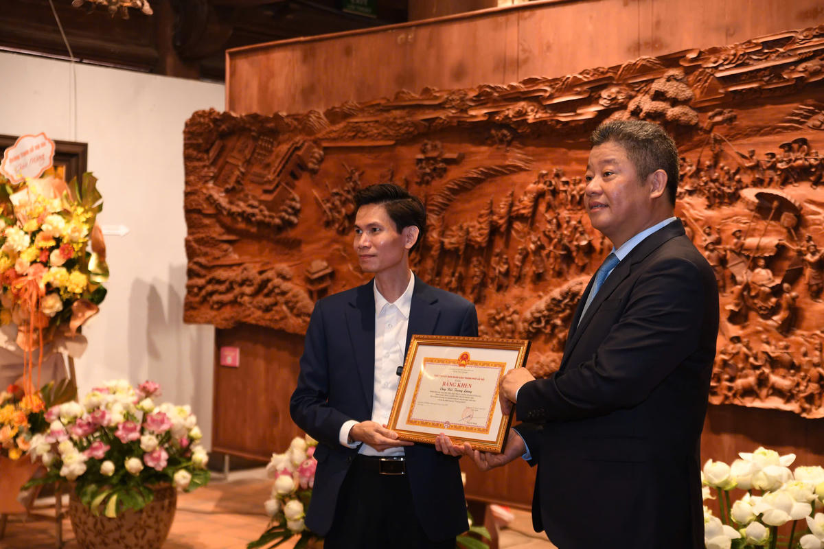 Phó Chủ tịch UBND thành phố Nguyễn Mạnh Quyền trao Bằng khen tặng nghệ nhân Bùi Trọng Lăng. Ảnh: Phạm Sỹ.