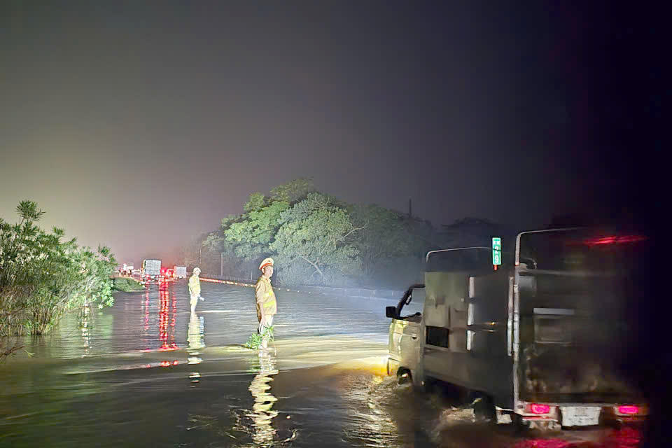 CSGT Hà Nội xuyên đêm 'làm cọc tiêu' tại điểm ngập trên cao tốc Hà Nội - Thái Nguyên để hướng dẫn xe đi qua an toàn. Ảnh: Lê Khánh