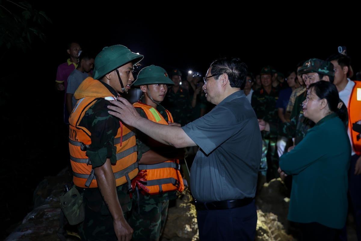 Thủ tướng động viên các lực lượng chức năng đang ứng phó với mưa lũ tại các xã Trung Giã, Đa Phúc. Ảnh: Nhật Bắc