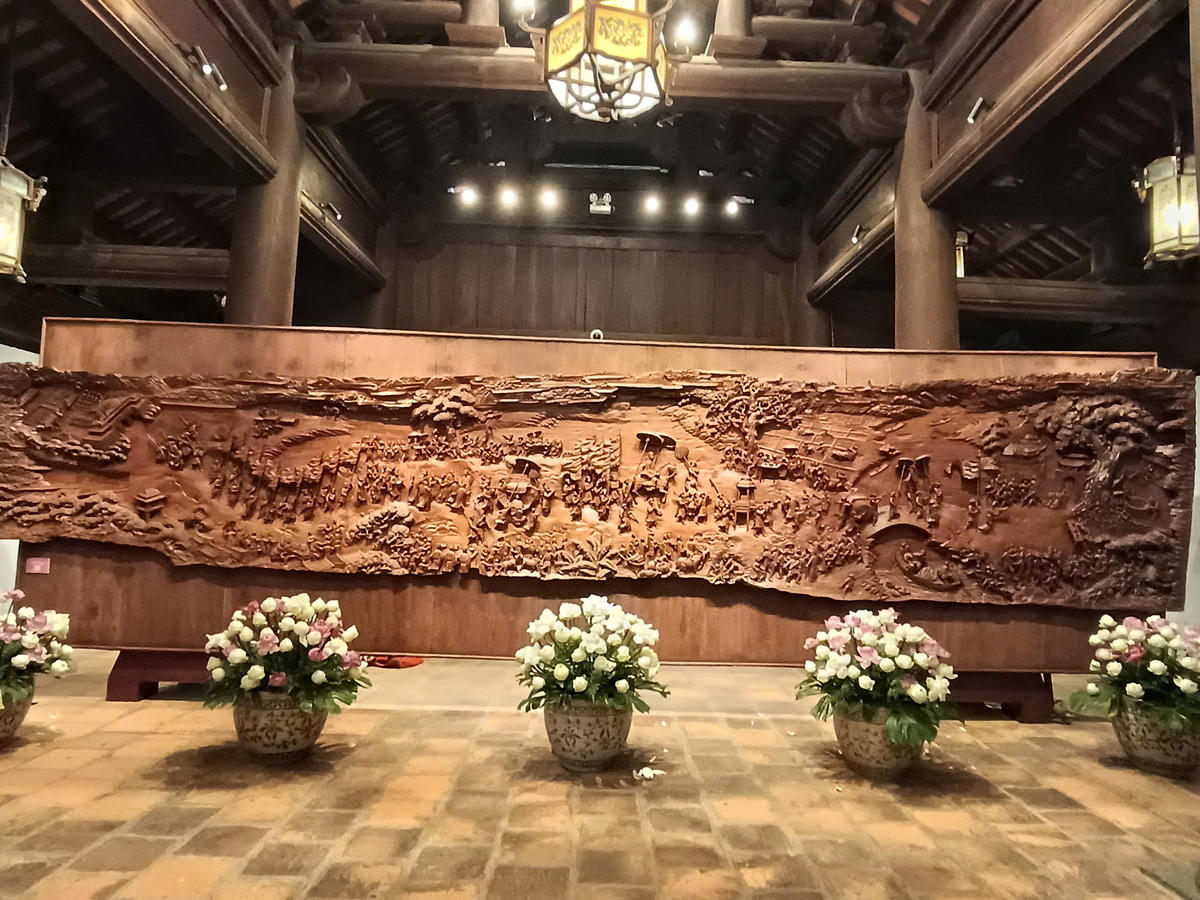 Tác phẩm “Vinh quy bái tổ” được chế tác từ gỗ Cẩm quý hiếm, với kích thước dài 8m33, rộng 1m70, dày 16cm. Ảnh: Phạm Sỹ.