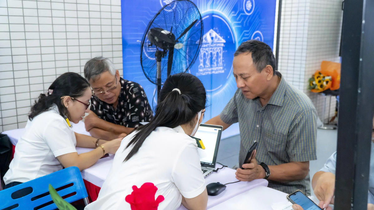 Hỗ trợ người dân, nhất là người lớn tuổi ứng dụng giao dịch điện tử trong giải quyết thủ tục. Ảnh: Thanh Nhã.
