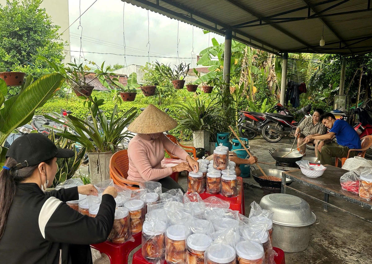 Người dân xã Đồng Dương đang đóng hộp những món ăn ngon gửi về đồng bào vùng lũ. Ảnh: CV.