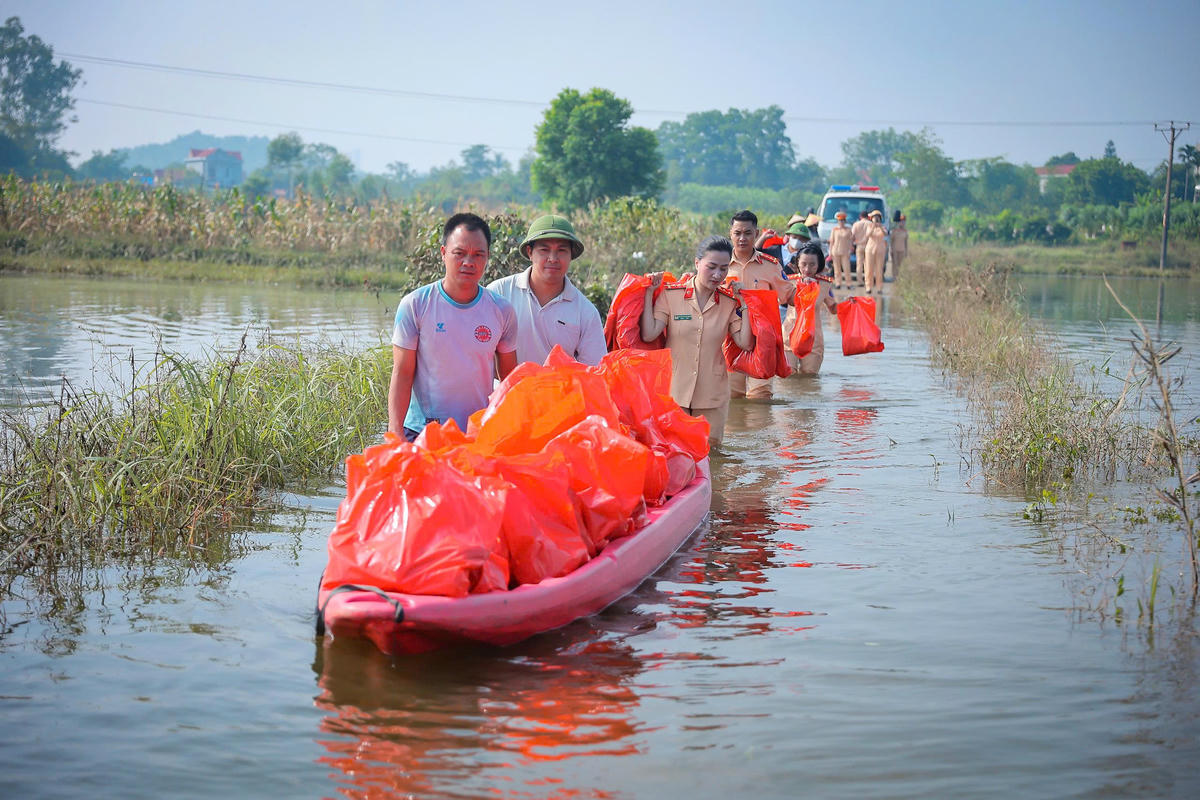 CSGT lội nước di chuyển đến trao quà cho người dân bị ngập.