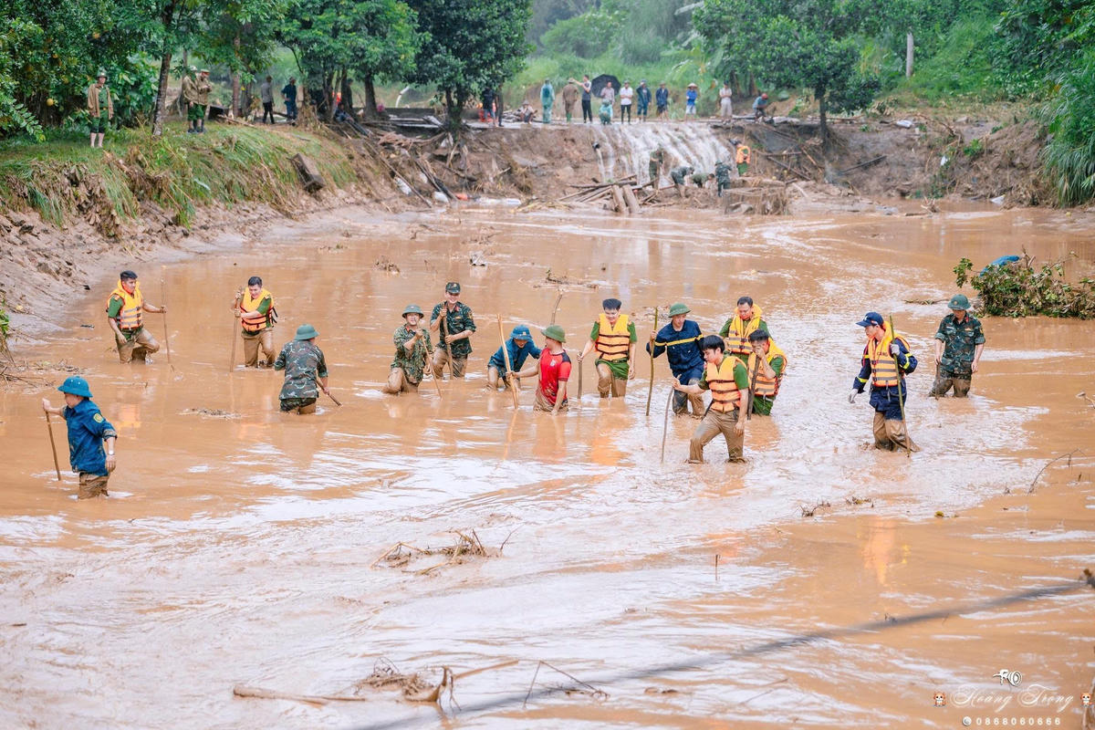 Các cán bộ, chiến sĩ thuộc Công an tỉnh Lào Cai dầm mình trong bùn đất để tìm kiếm cứu nạn. Ảnh: Hữu Đức.