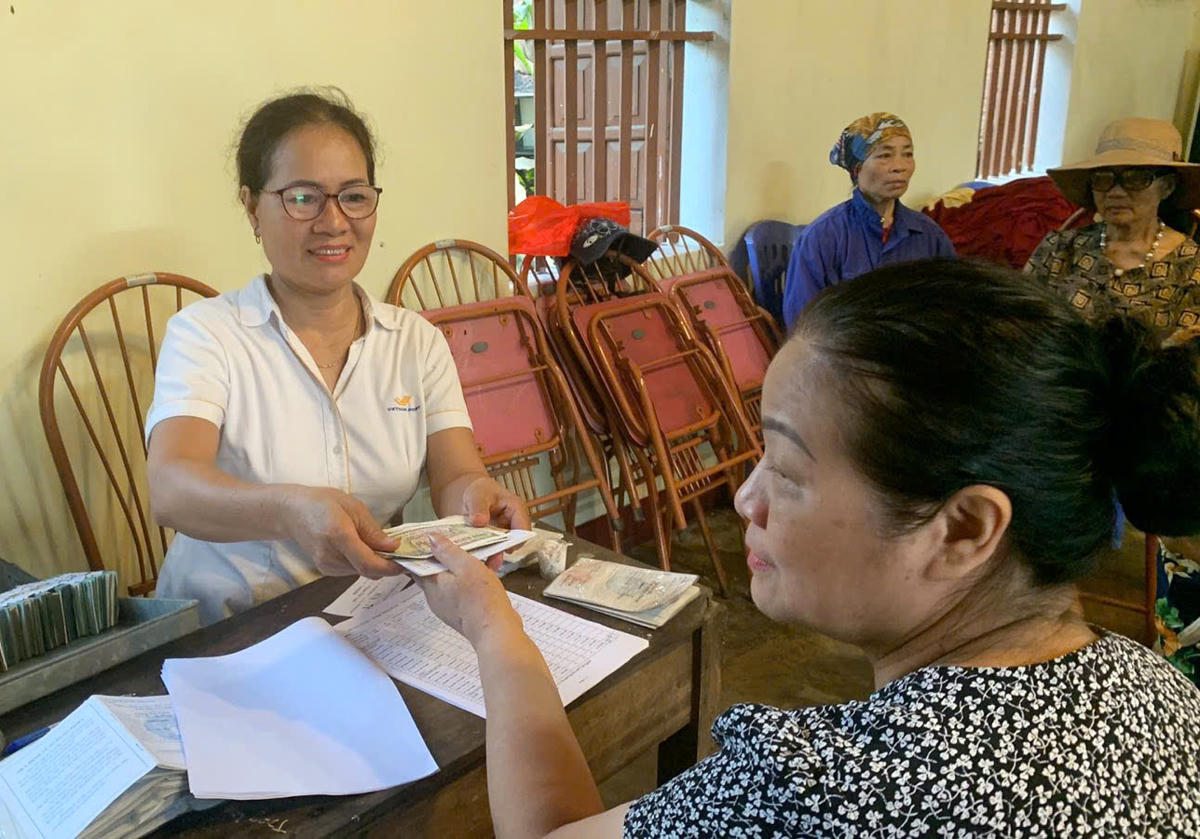 Nhân viên Bưu điện chi trả lương hưu cho người hưởng tại Nhà văn hóa tổ 6 Bà Hồng, phường Tân Long (cũ).