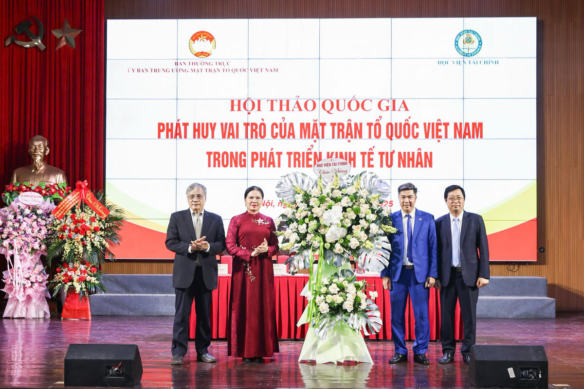 Phó Chủ tịch Hà Thị Nga và lãnh đạo Học viện Tài chính tặng hoa chúc mừng Hội thảo. Ảnh: Quang Vinh.