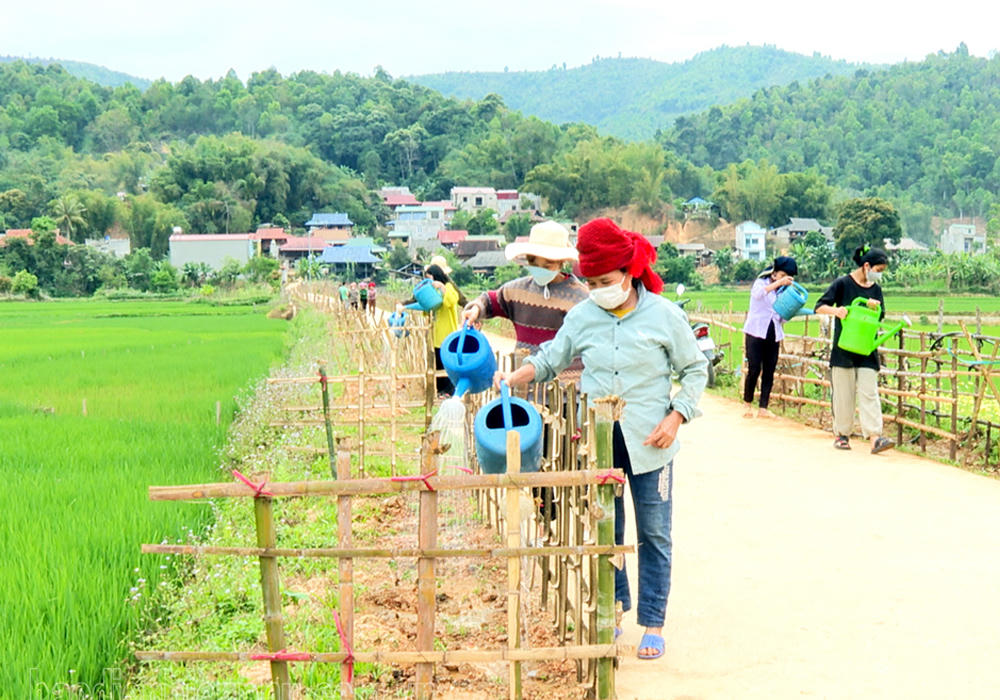 Người dân xã Quài Tở (tỉnh Điện Biên) chăm sóc đường hoa vào bản. Ảnh: Lường Phượng
