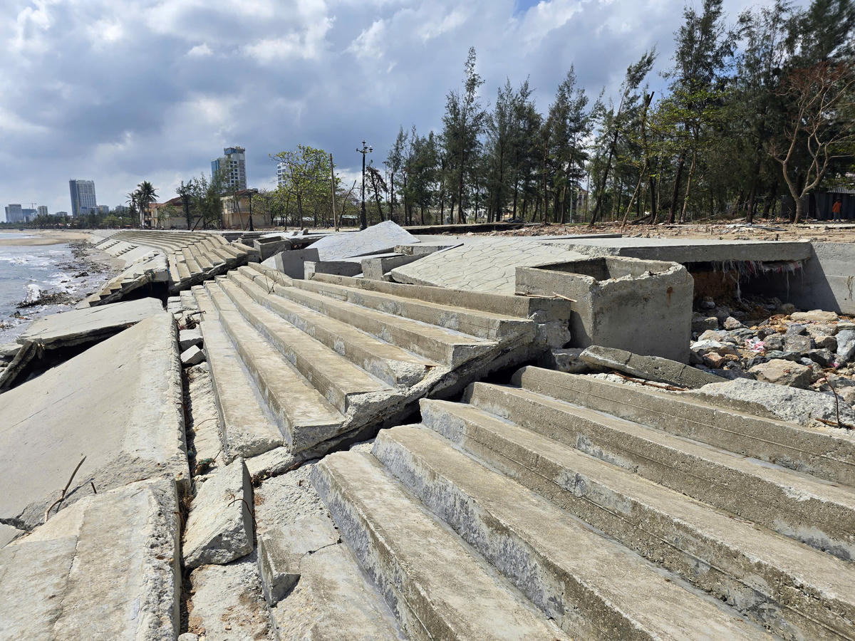 Khoảng 50m kè bị biến dạng hoàn toàn, nhiều vị trí nứt toác, sụt lún, tạo nên cảnh tượng tan hoang. Ảnh: ĐB