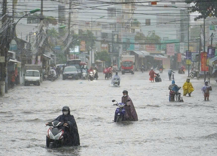 Người dân dắt xe qua vùng nước ngập ở đường 2/4. (ảnh X.H) 