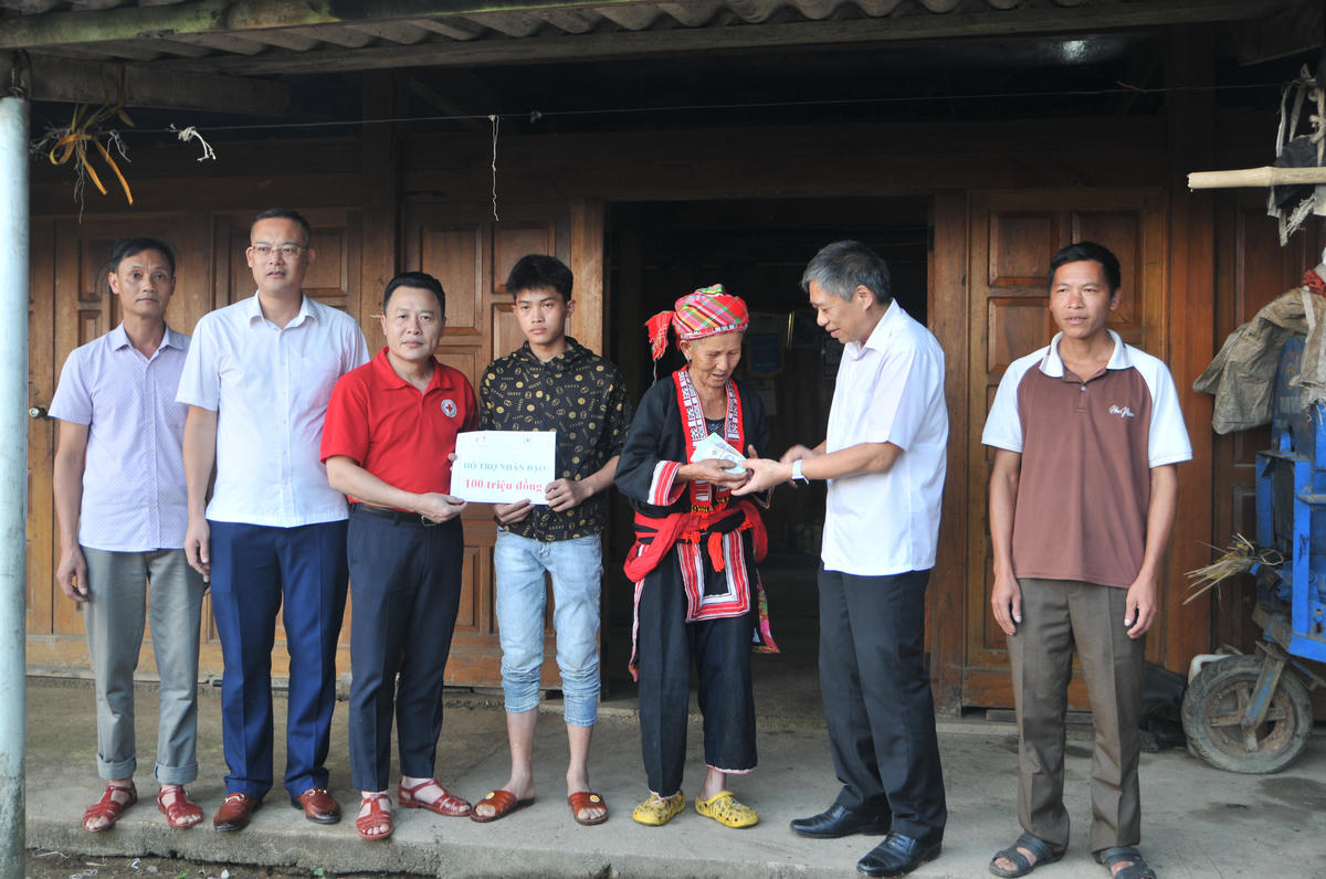 Ông Nguyễn Hồng Trang, Phó Bí thư Đảng ủy các cơ quan đảng tỉnh Tuyên Quang và Đoàn công tác trao số tiền 100 triệu đồng hỗ trợ gia đình nạn nhân bị lũ cuốn trôi. Ảnh: Xuân Trường.