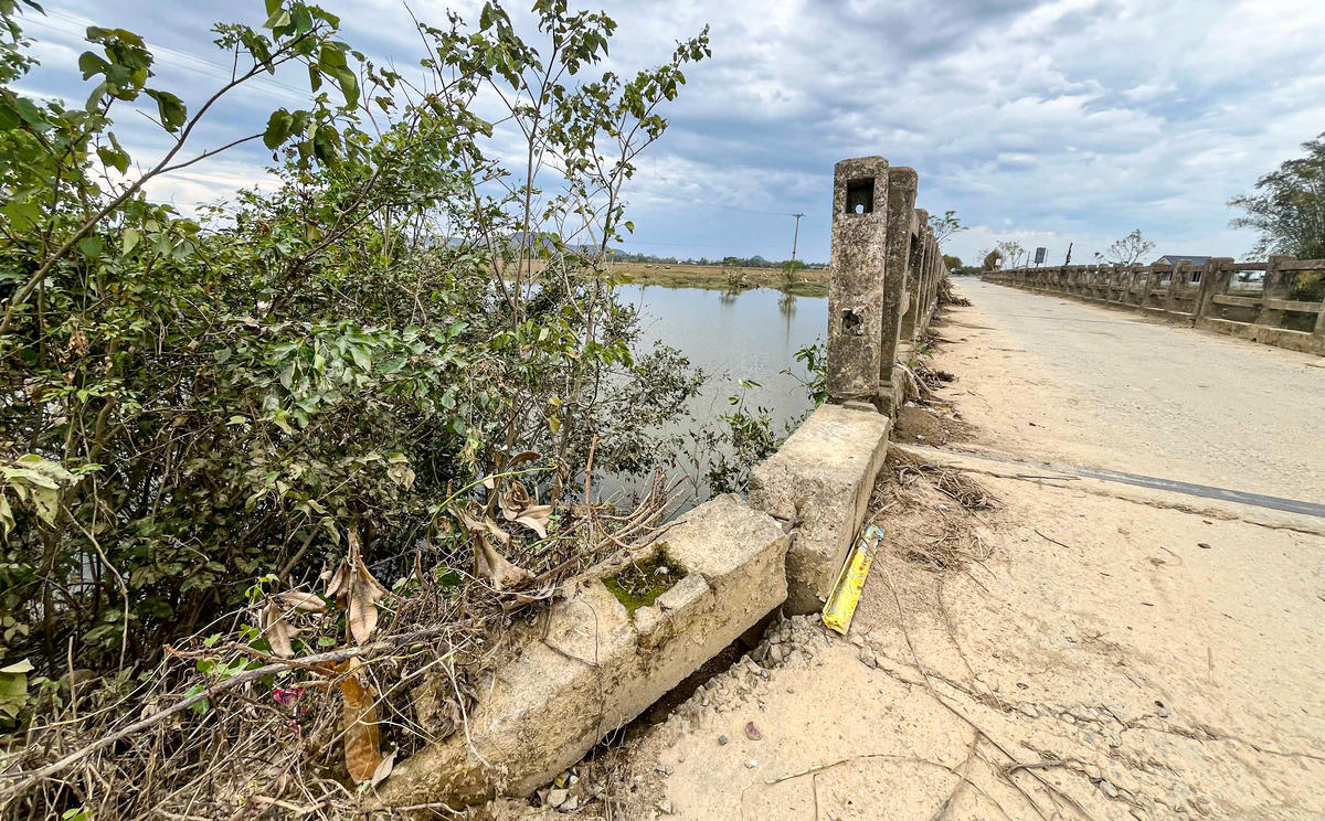 Hai bên đầu cầu, nền đường bị sụt lún, tạo thành những rãnh sâu, mỗi khi mưa xuống lại đọng nước. Ảnh: Cẩm Kỳ