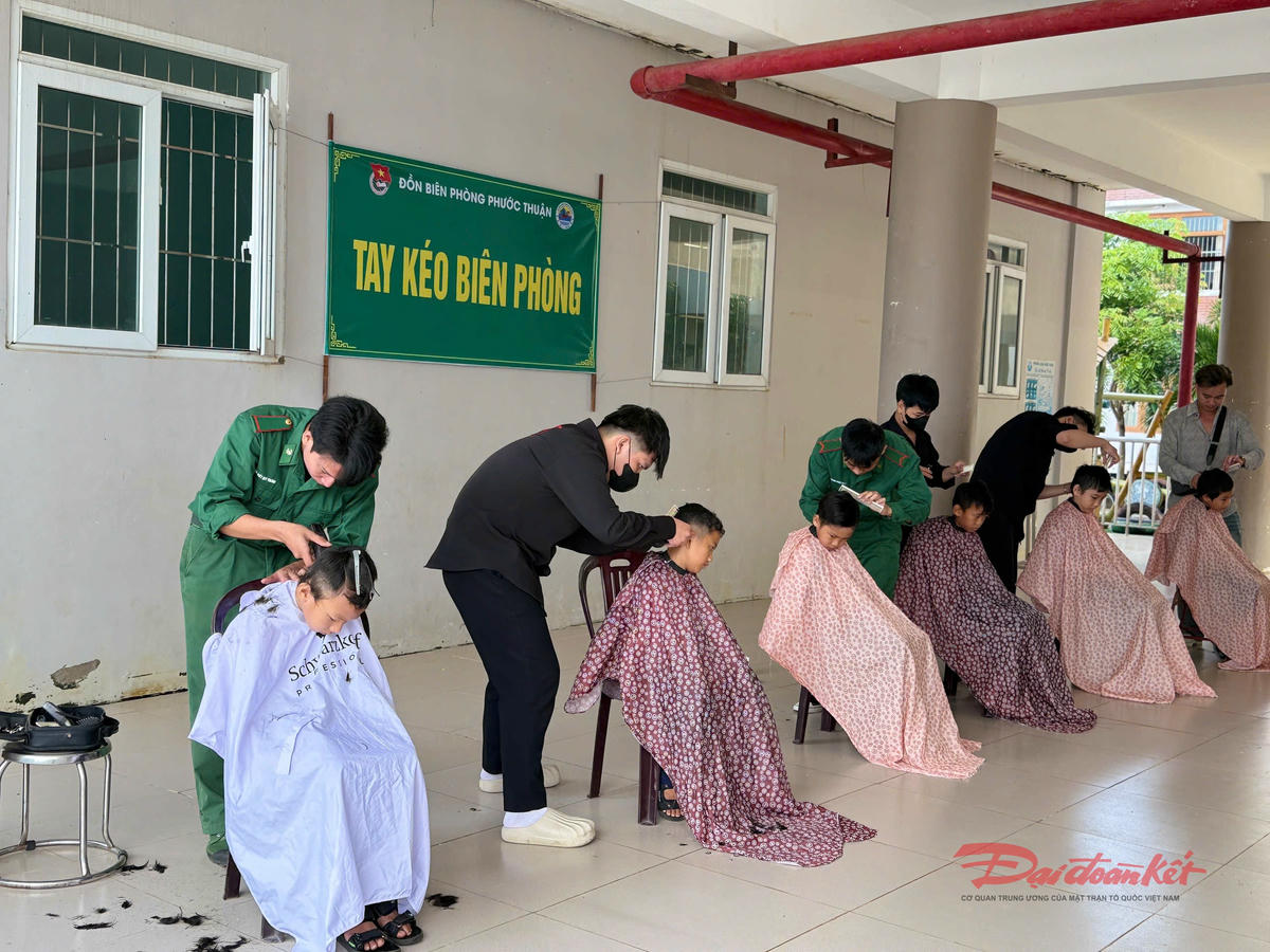 Tổ “Tay kéo Biên phòng” cắt tóc miễn phí cho các em học sinh. Ảnh: Quang Tiến.