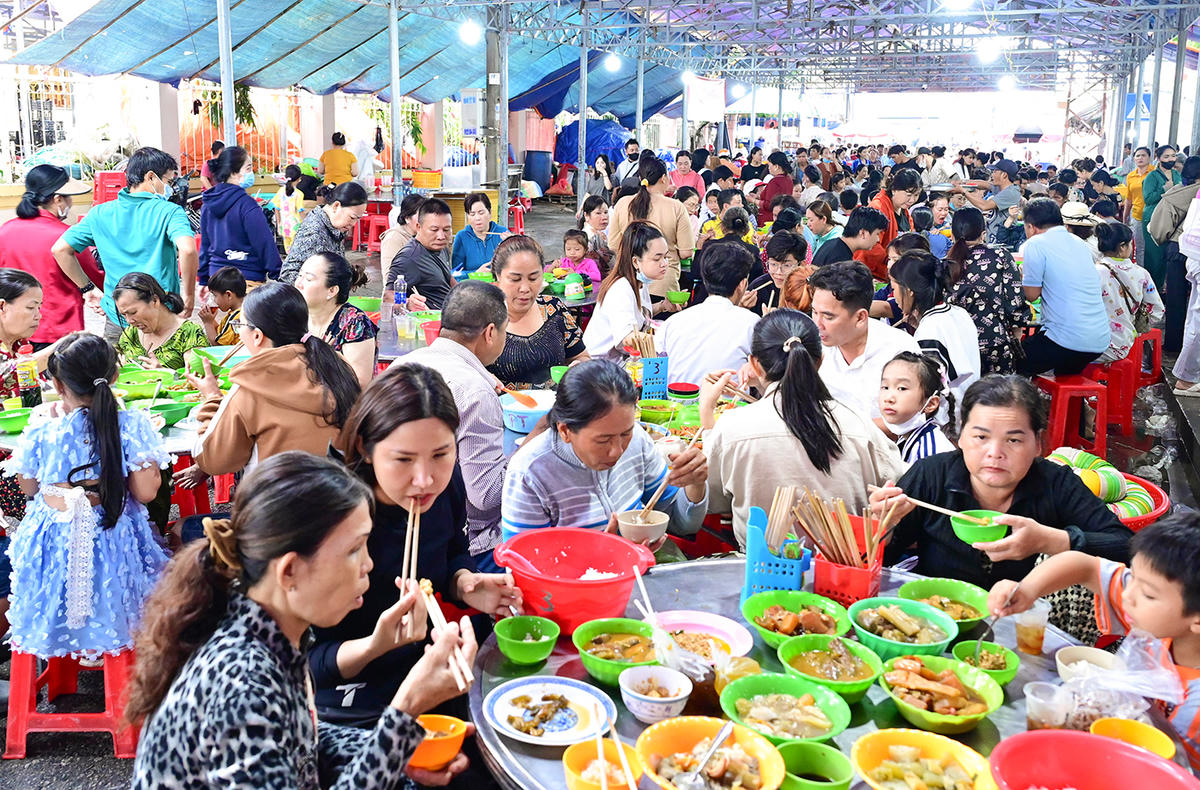 Khách thập phương thưởng thức cơm chay miễn phí khi về dự lễ. Ảnh Nguyễn Minh.